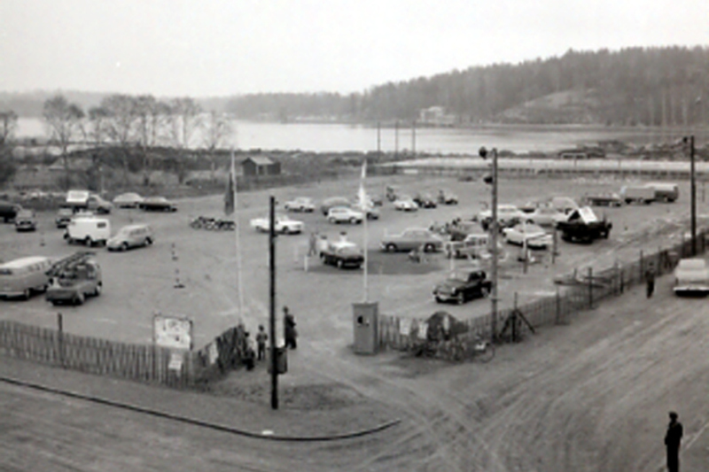 Svartvit historisk bild på Vegaplan, beläget i hamnen i Norrtälje. En stor parkeringsyta med ett tjuotal bilar uppställda.