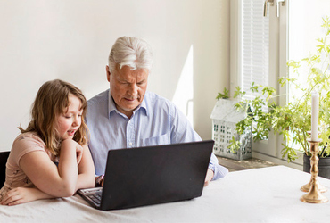 Man med barnbarn vid dator lämnar e-förslag.