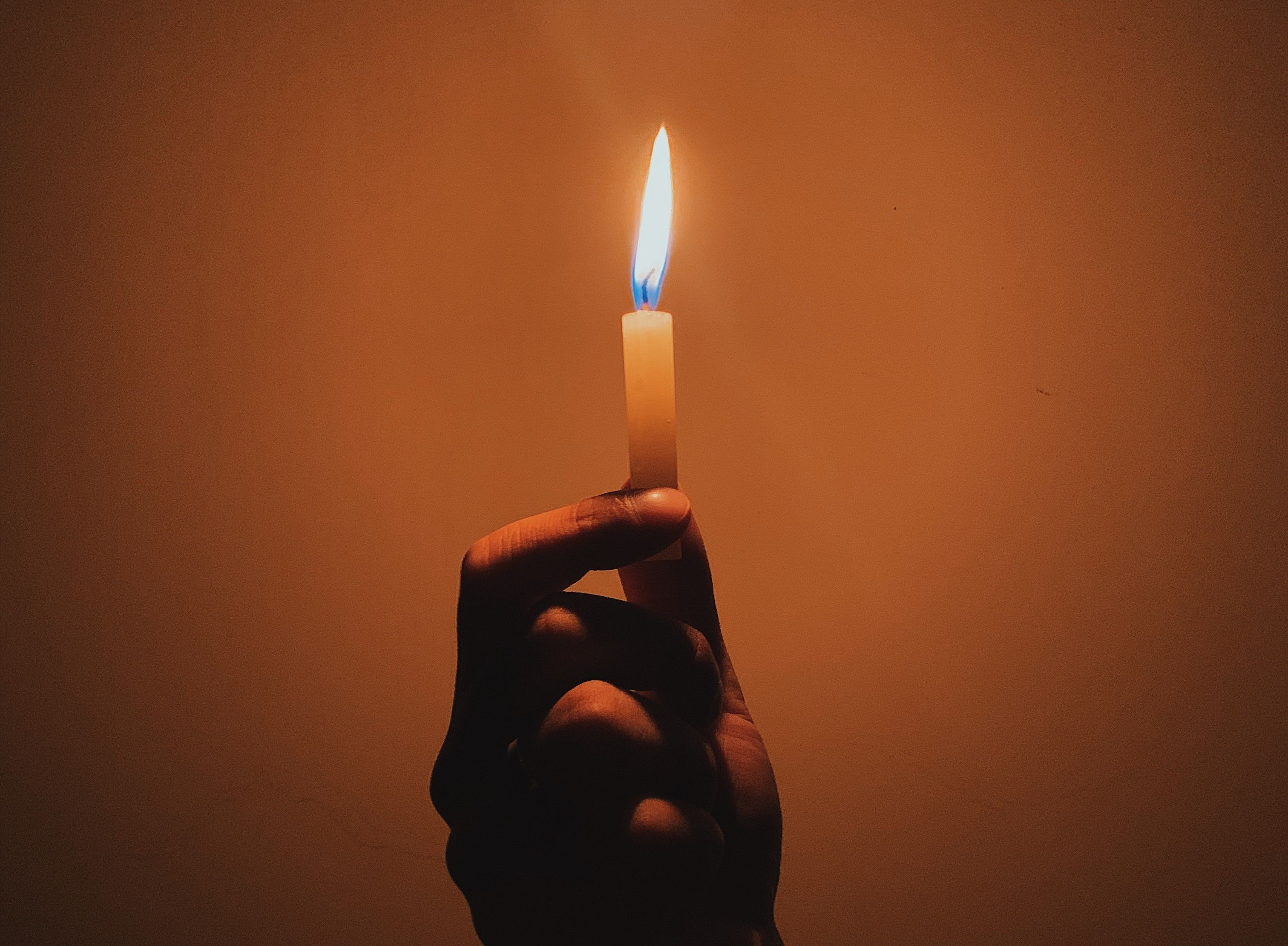 Ett tänt ljus som symboliserar omtanke, minne och hopp på suicidpreventiva dagen