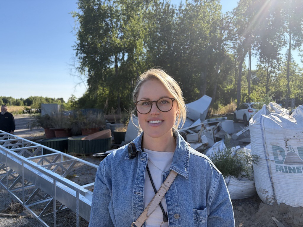 Leende person framf&ouml;r byggutrustning