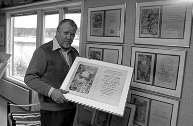 Gunnar Brusewitz står i sin atelje. På väggen syns ett antal Nobeldiplom och i handen håller han ett.