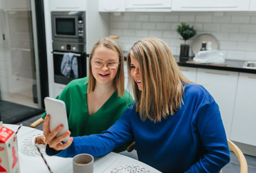 Tjejer tar  selfie vid matbord