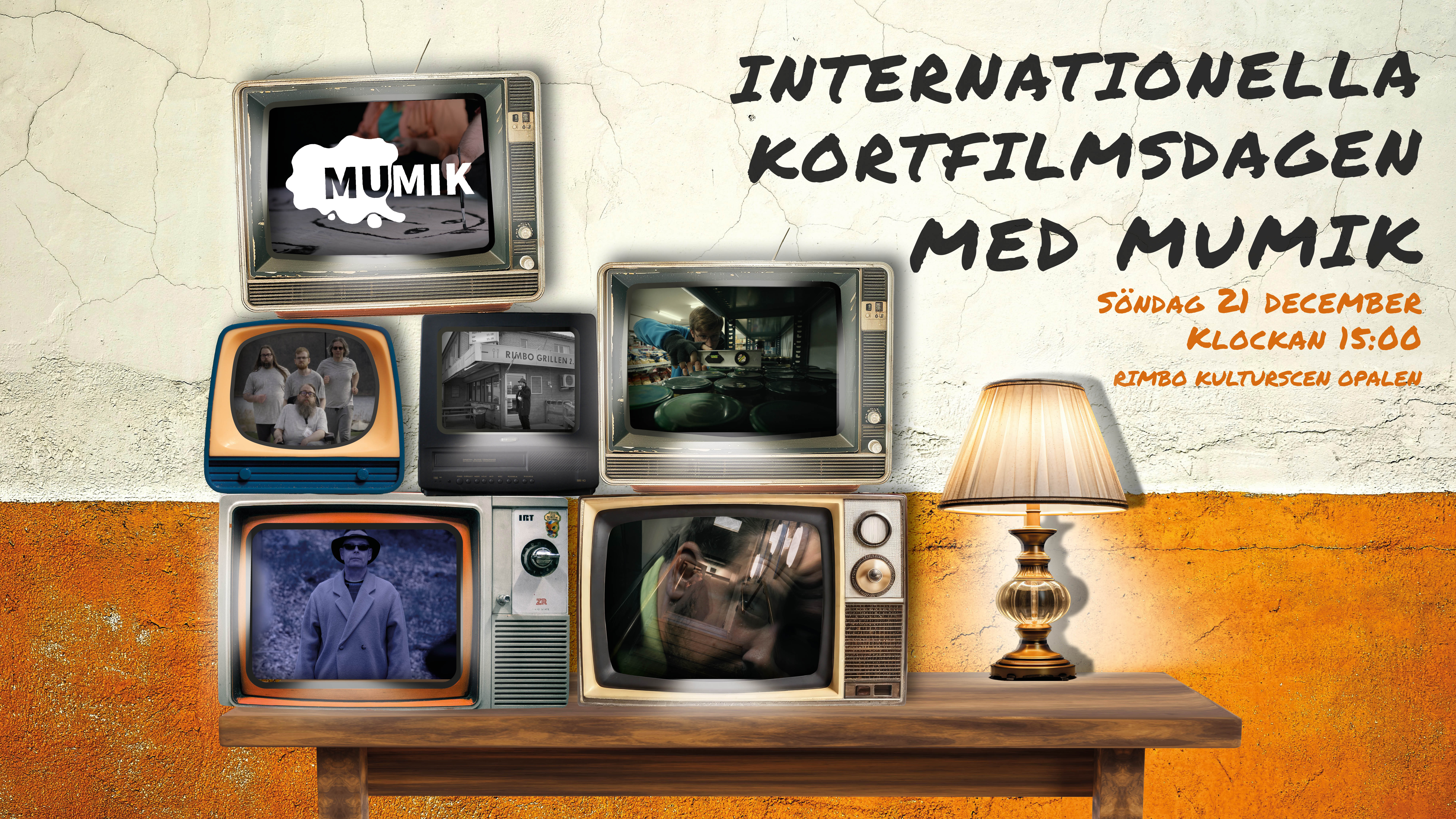 En TV-bänk med flera gamla TV-apparater staplade på varandra. Varje skärm visas en stillbild från kortfilmerna. Längst till höger står en lampa med mysig belysning