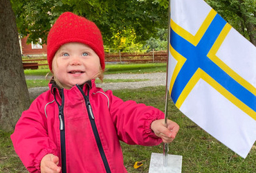 Glad bebis viftar med sverigefinska flaggan
