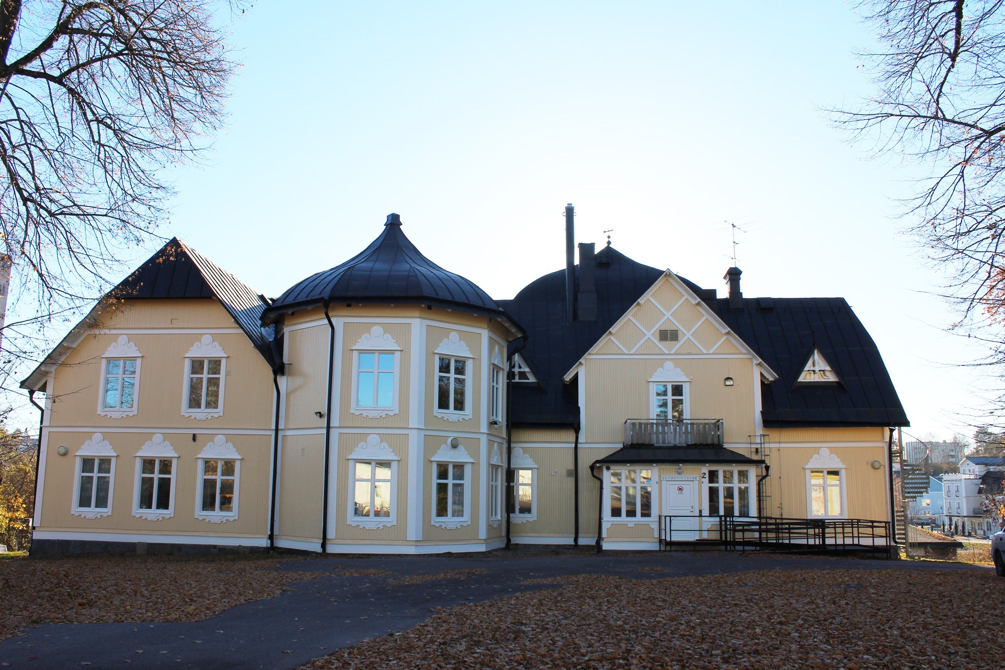 Bild på byggnaden. Ett gult ändre hus med vita knutar. 