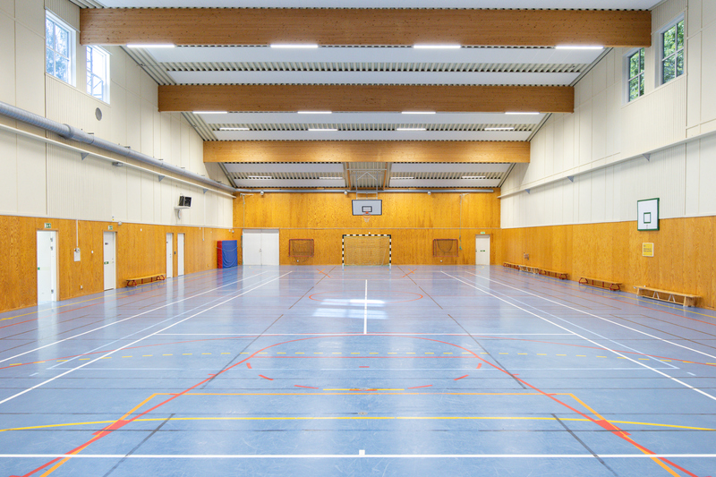 Stor sporthall med blått golv och basketkorg