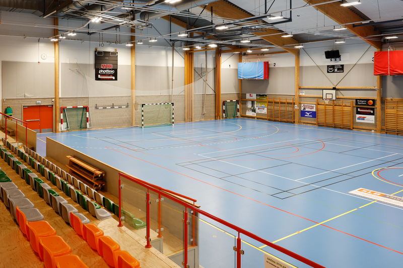 Sporthall med publikläktare, ribbstolar, basketkorg och fotbollsmål