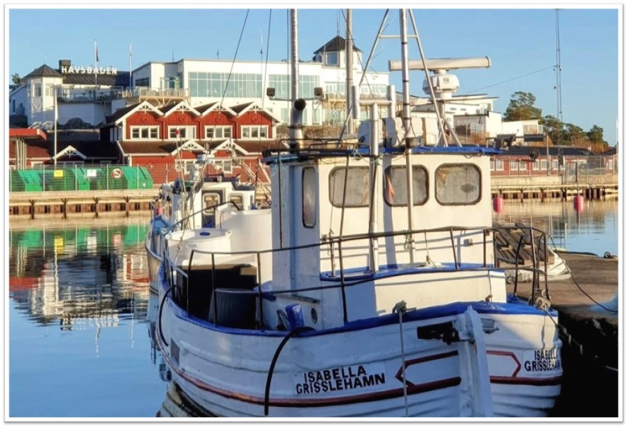 Bild från Grisslahamn, fiskebåt i förgrunden och hotell havsbaden i bakgrunden