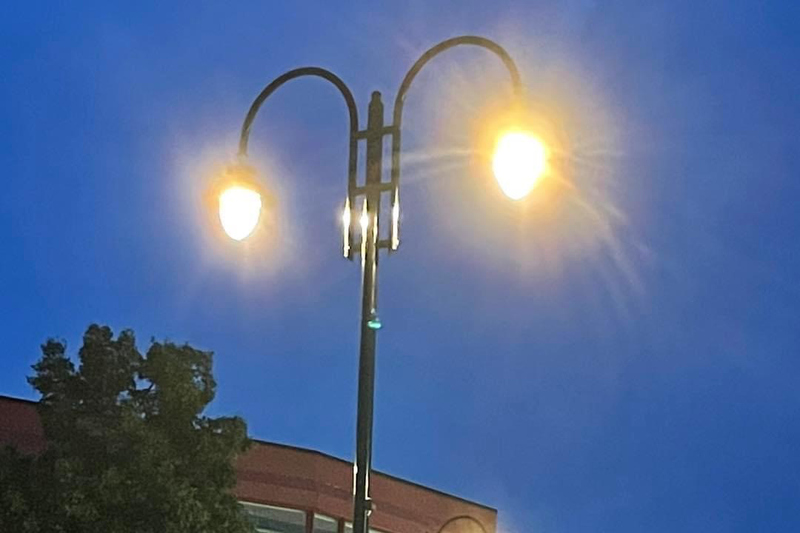 Stora droppformade lampor utanför en brun byggnad på hallstaviks torg