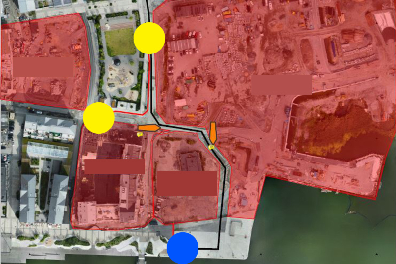 Bild på en karta som föreställer Norrtälje hamn, två gula cirklar markerar var grindar till området finns, en blå cirkel markerar var uppställningsplatsen är och ett svart sträck visar vilken väg man ska köra.