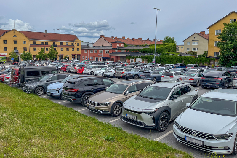En parkeringsplats full av parkerade bilar.