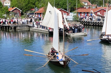 Postroddsbåten Maria av Gräsö tas emot av åskådare vid målgång i Grisslehamn.