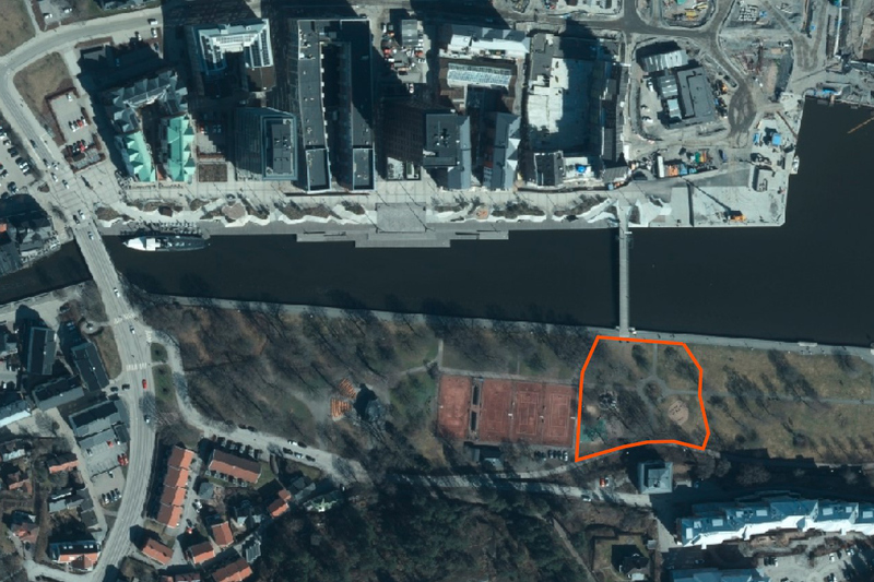 Flygbild över Norrtälje hamnområde och grönområdet Societetsparken med en del av parken inringat i orange