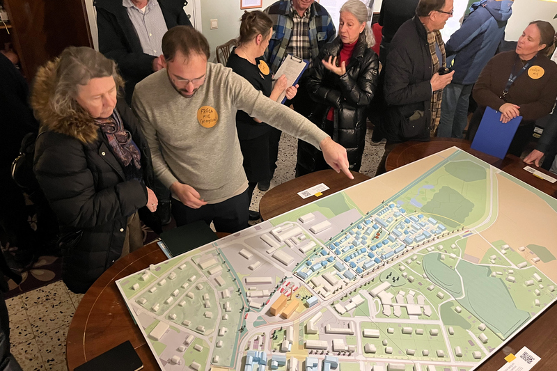 Människor samlade runt en modell för centrala rimbo