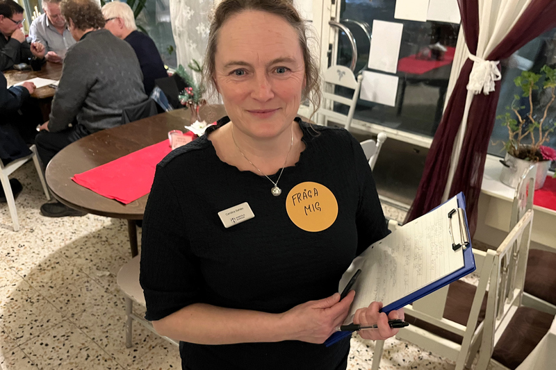 en kvinna står med ett anteckningsblock