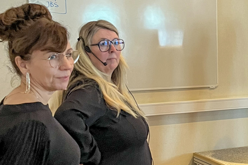 Två kvinnor klädda i svart med glasögon.