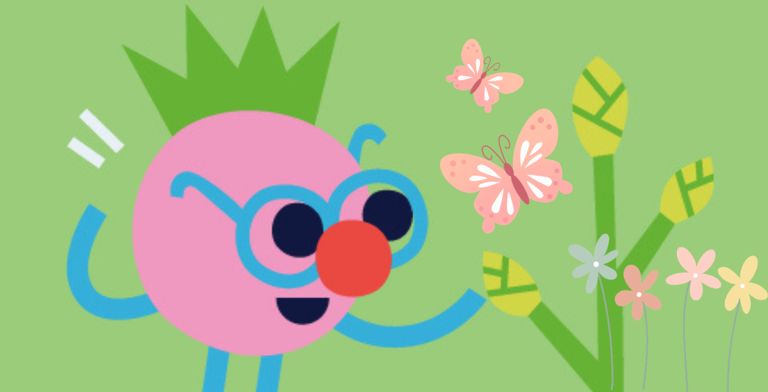 En rosa maskot står bredvid ett par blommor. Några fjärilar flyger ovanför. 