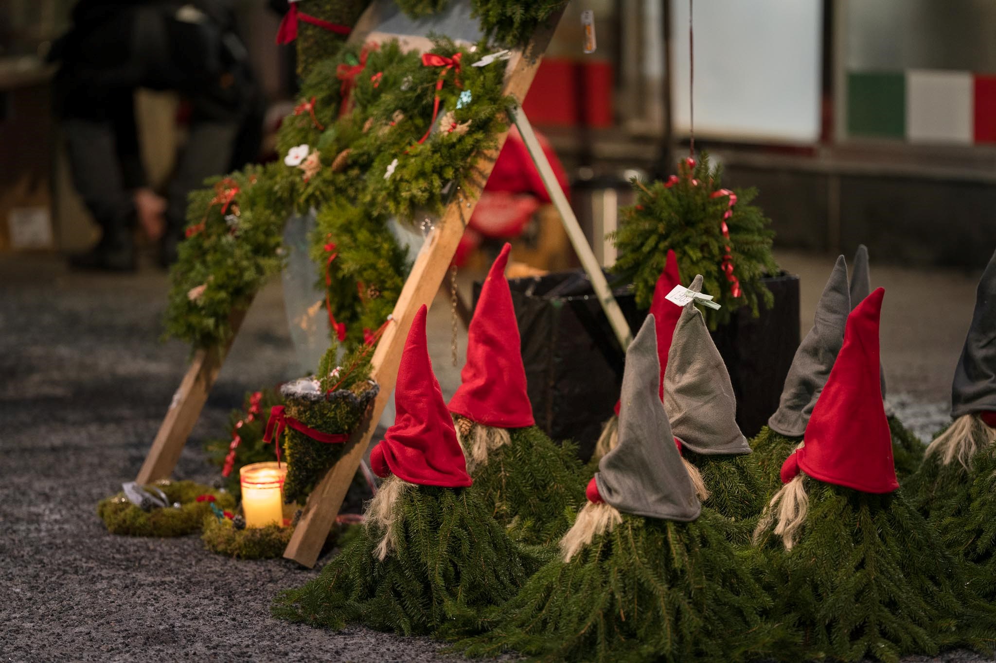 Julpynt i form av tomtar gjorda av granris utställda på marken.