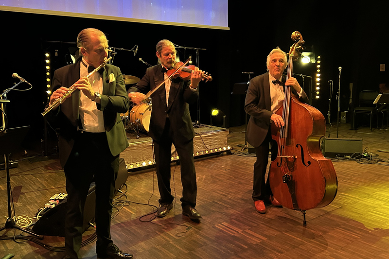 Tre m&auml;n p&aring; scen som spelar instrument