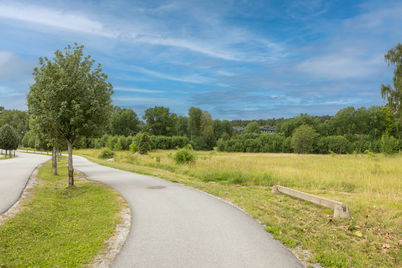 Gr&ouml;nomr&aring;de med slingrande g&aring;ng- och cykelv&auml;g genom.