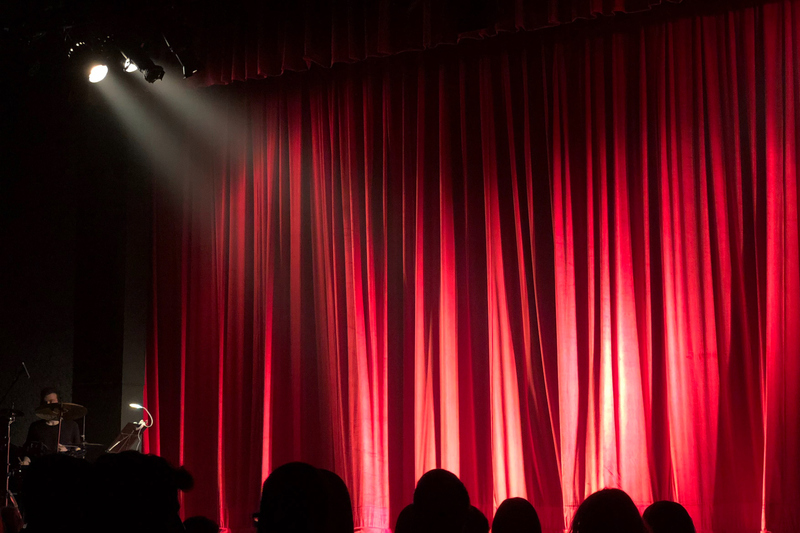Bild av en scen med en röd ridå och en spotlight