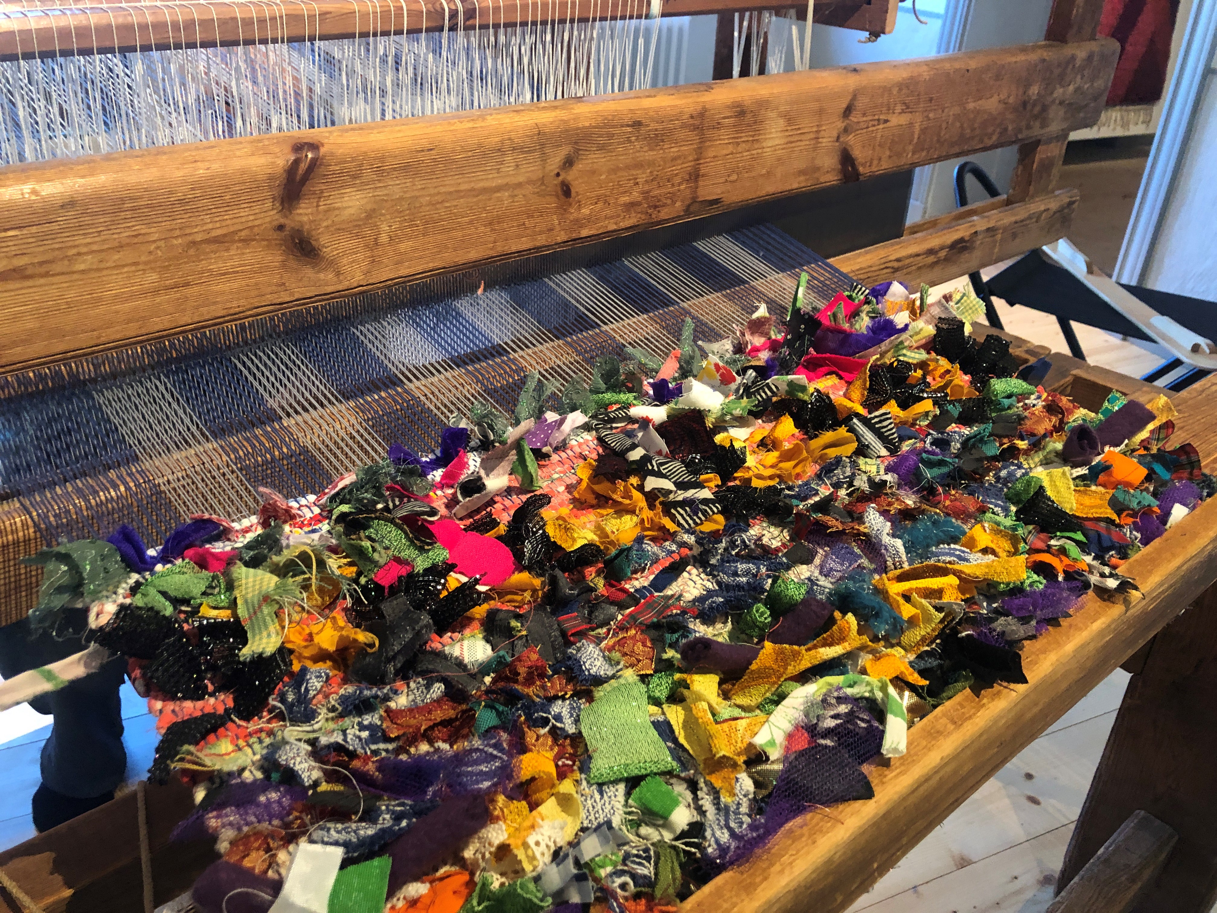 En vävstol med färgglada trasor i. 