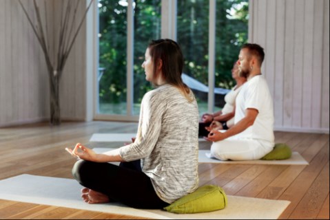 Två personer som sitter i lätt meditationsställning.