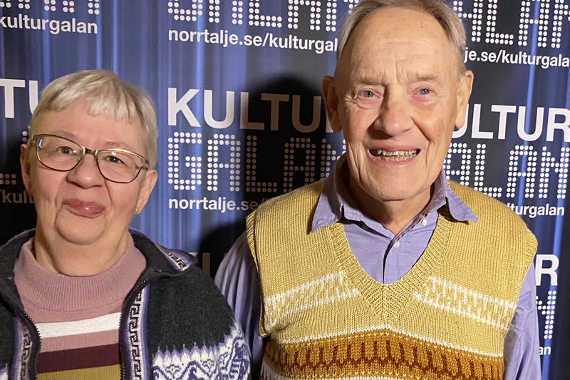 Annika och Jan-Olov Ivarsson står framför en blå fotovägg där det står kulturgalan.