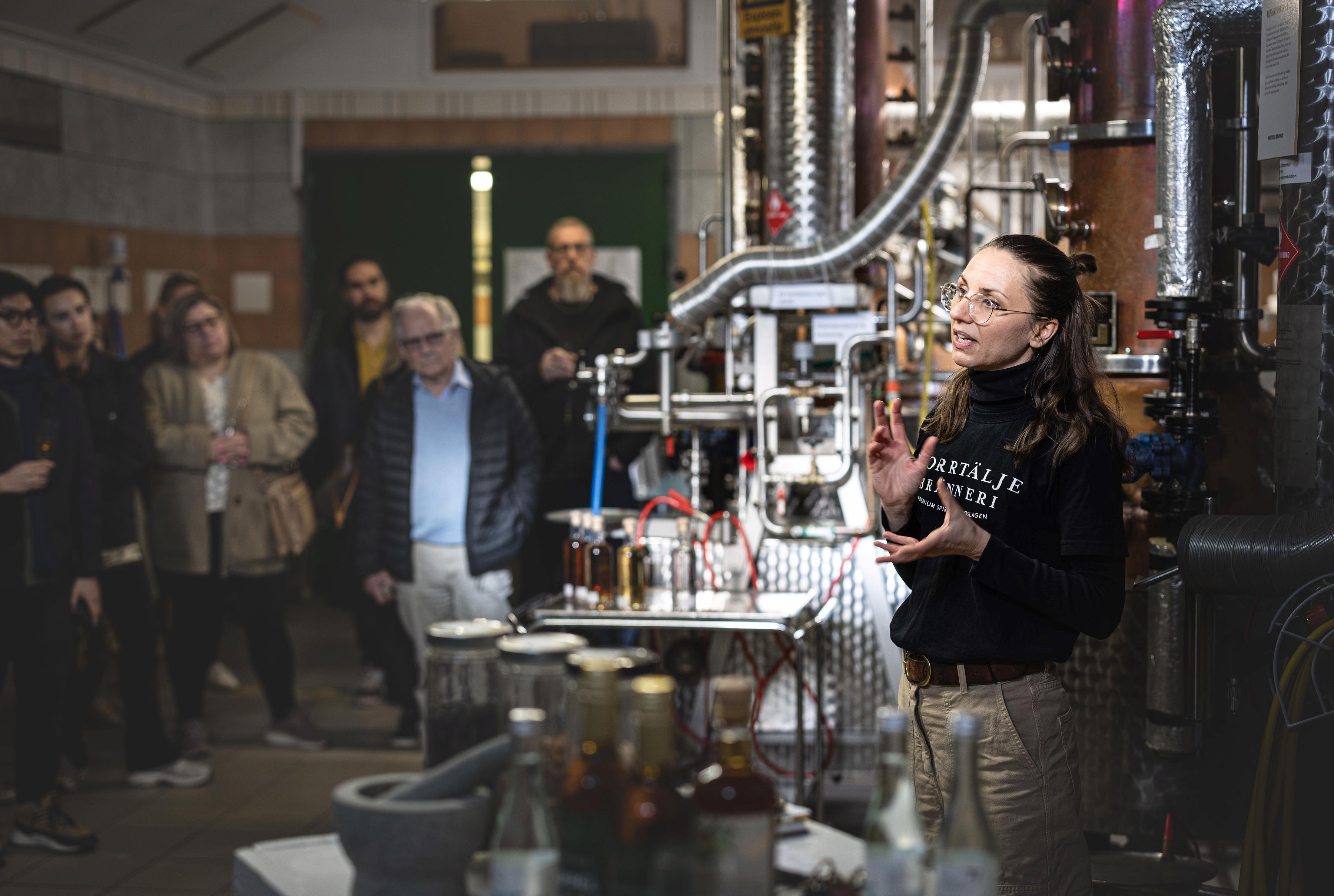 Guide som berättar för en grupp personer framför en kopparpanna