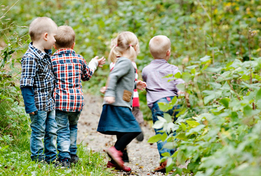 Fyra barn ute i skogen.