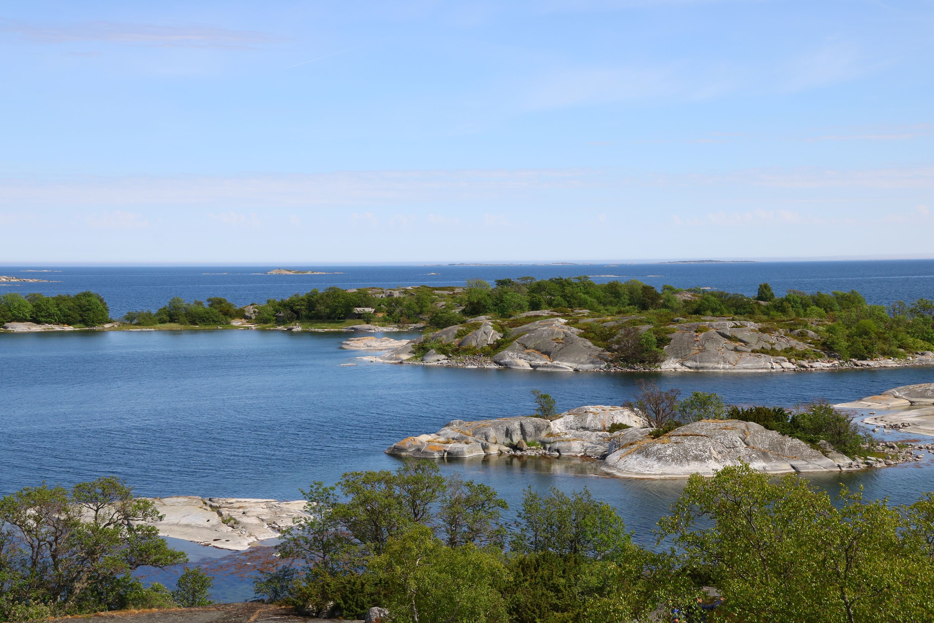 Bilden visar vatten, klippor och träd.