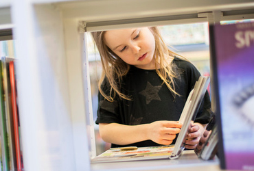 Ett barn som läser en bok på biblioteket. Foto från Simple Scandinav.
