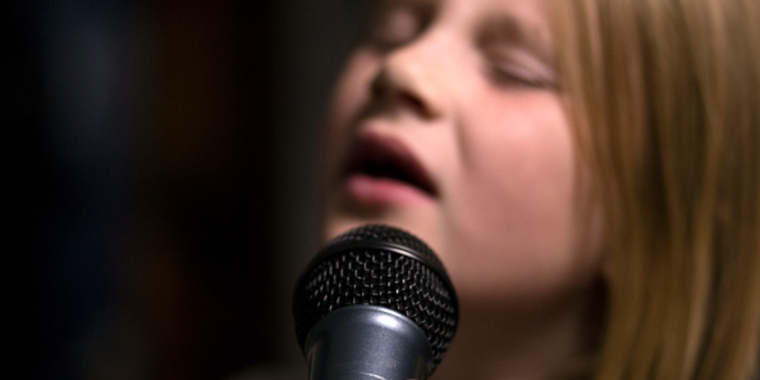 Barn som sjunger i en mikrofon.