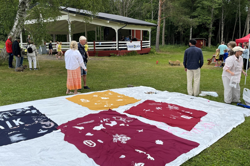 en stor flagga i förgrunden och människor i bakgrunden